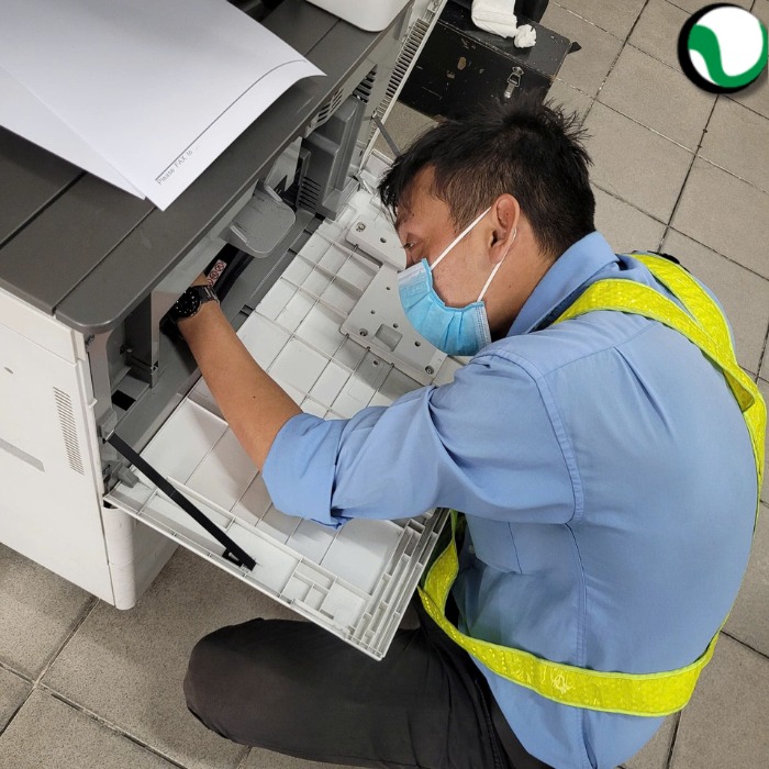Kỹ thuật viên Chí Vinh đang lắp đặt máy photocopy Ricoh cho văn phòng tại Bình Thạnh