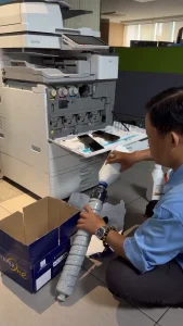 Kỹ thuật viên Chí Vinh thay mực máy photocopy màu Ricoh tại văn phòng, không tính thêm phí