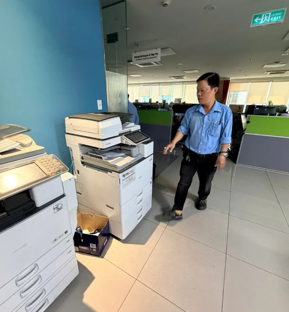 Kỹ thuật viên Chí Vinh kiểm tra máy photocopy màu Ricoh MP C4504 tại văn phòng khách hàng